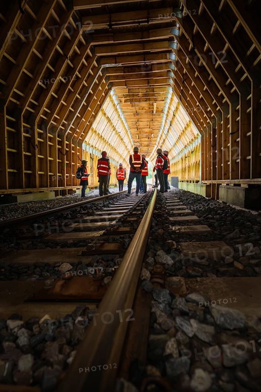 Groups of workers in a wooden railway tunnel, illuminated from the inside, construction of the Hermann Hesse railway, Calw, Black Forest, Germany