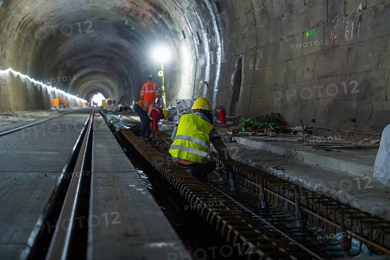 Construction workers in the tunnel working on the tracks. The scene is illuminated by strong light, construction of the Hermann Hesse railway, Calw, Black Forest, Germany