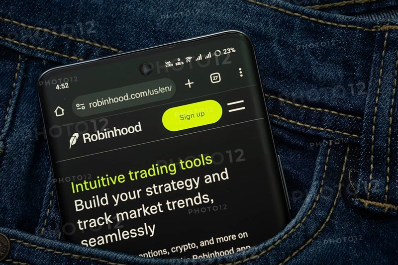 Dhaka, Bangladesh- 15 June 2025: A smartphone displaying the Robinhood web interface peeks out of a denim pocket