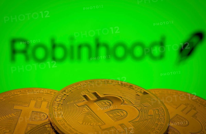 Dhaka, Bangladesh- 20 Sep 2025: Close-up of Bitcoin coins with the Robinhood Markets logo visible on a screen in the background