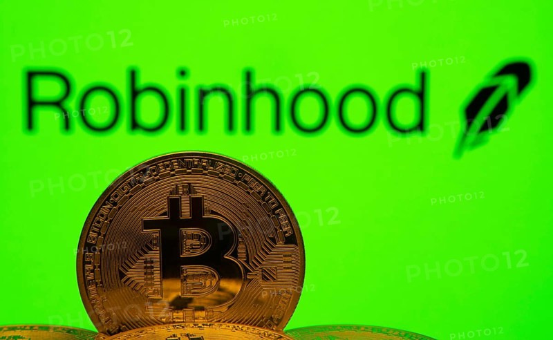 Dhaka, Bangladesh- 20 Sep 2025: Close-up of Bitcoin coins with the Robinhood logo visible on a screen in the background