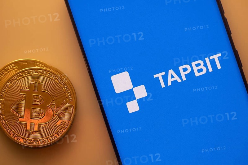 A Bitcoin and Tapbit logo on a blue screen representing cryptocurrency