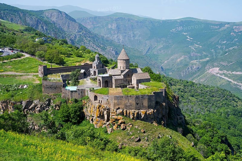An ancient monastery sits majestically on a hill overlooking a mountainous landscape, Tatev Monastery, Tatev, Armenian Apostolic Monastery, Syunik Province, Syunik, Armenia