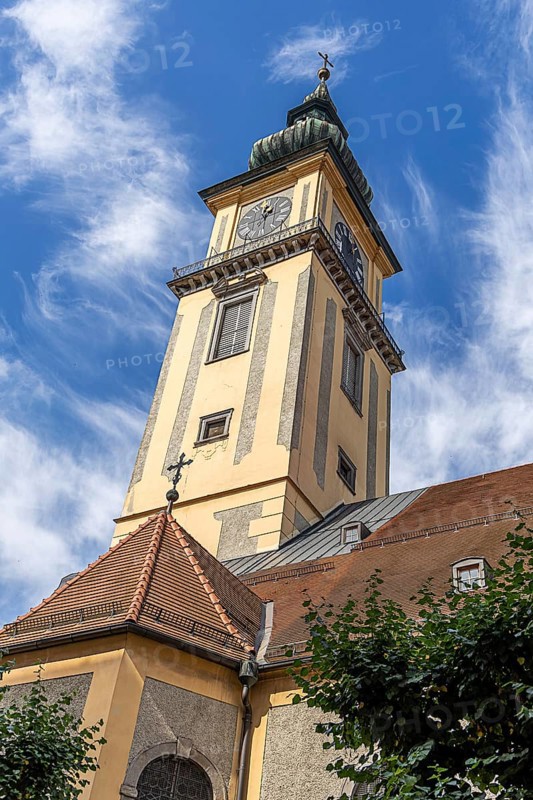 Baroque church tower with clock against a blue sky with light clouds, Old Town Linz Upper Austria Austria