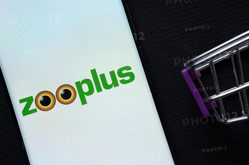 Dhaka, Bangladesh- 03 July 2025: A smartphone displaying the zooplus logo next to a miniature shopping cart on a background