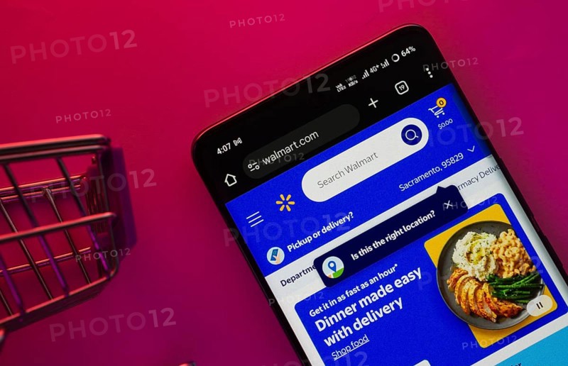 Dhaka, Bangladesh- 23 June 2025: A smartphone displaying the Walmart website with a shopping cart is shown on a vibrant background