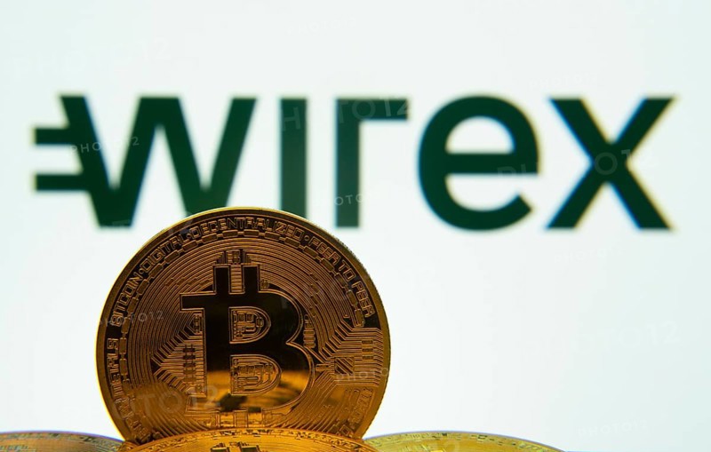 Dhaka, Bangladesh- 04 April 2025: Close-up of Bitcoin coins with the wirex logo visible on a screen in the background