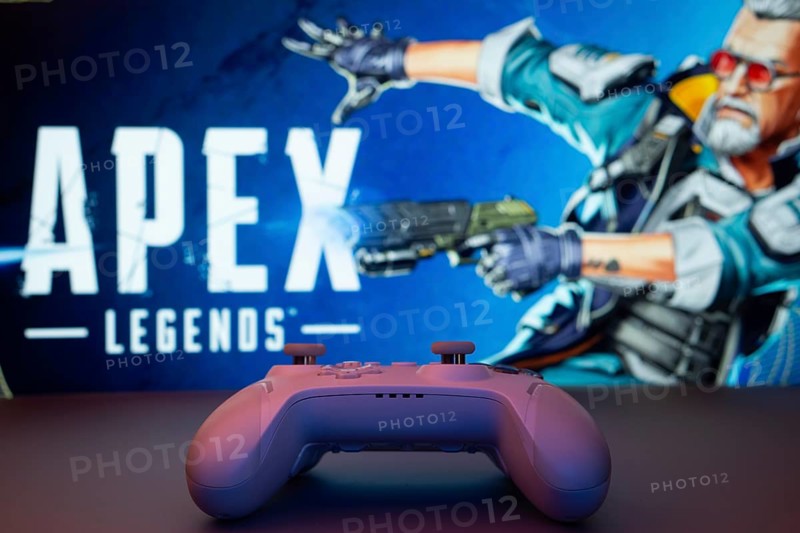 Dhaka, Bangladesh- 19 Sep 2025: A close-up of a white gamepad with the Apex Legends seen on screen in the background