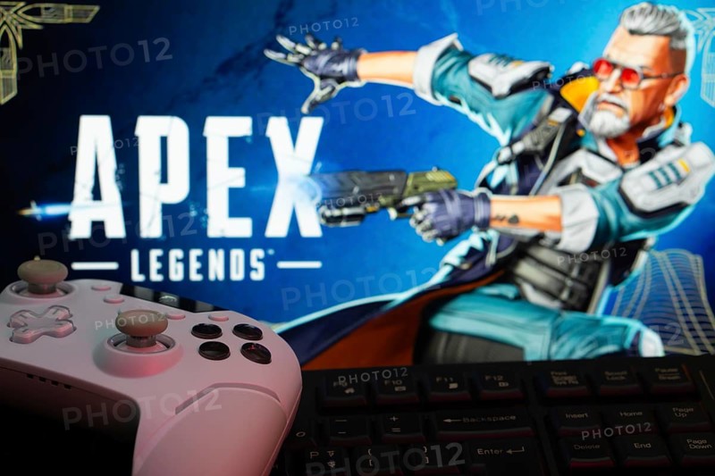 Dhaka, Bangladesh- 19 Sep 2025: A close-up of a white gamepad with the Apex Legends seen on screen in the background