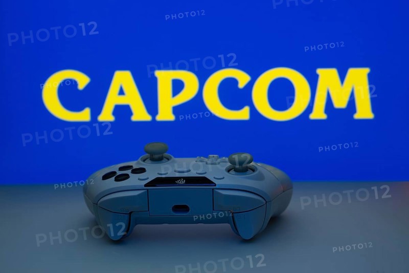 Dhaka, Bangladesh- 19 Sep 2025: A close-up of a white gamepad with the Capcom seen on screen in the background