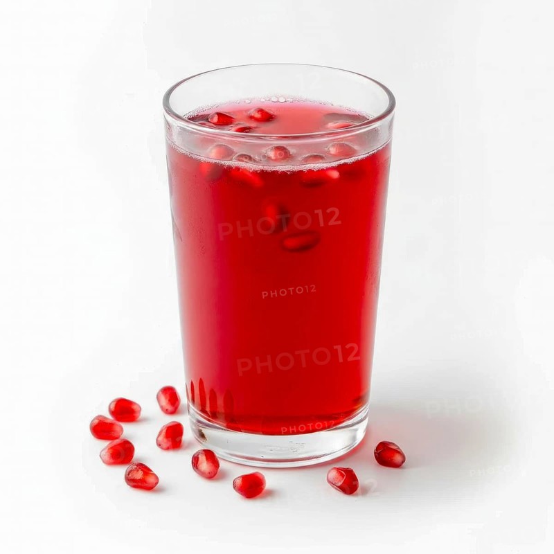 A vibrant image showcasing a glass of fresh pomegranate juice, garnished with seeds, set against a clean white backdrop, AI generated