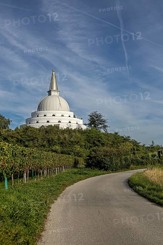 White pagoda surrounded by green nature and meadows under a blue sky, Stupa am Wagram Grafenwörth Weinviertel Lower Austria Austria