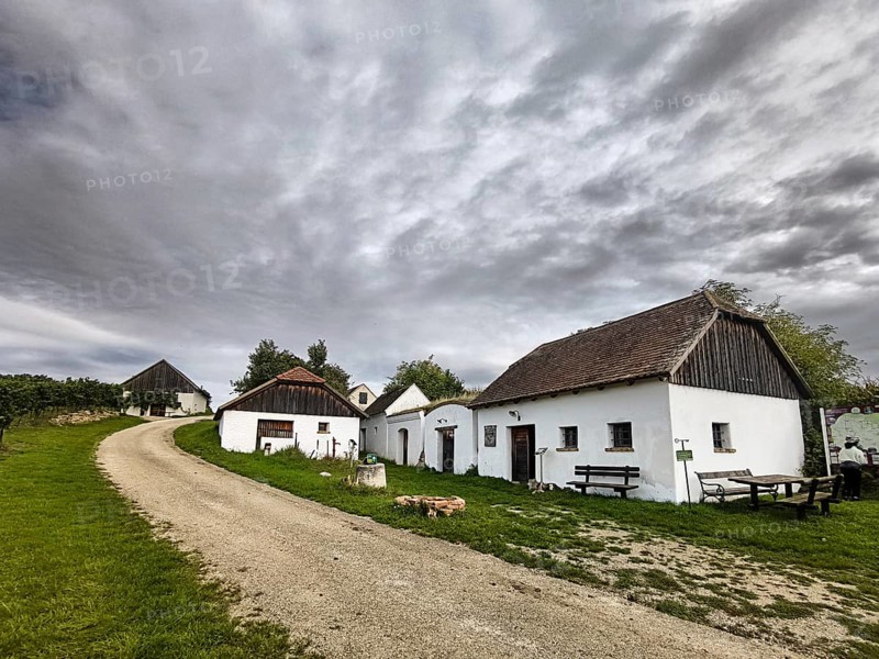 A group of old, traditional houses along a cobbled path under an expansive sky, Kellergasse Hart -Aschenbach Hollabrunn Weinviertel Lower Austria Austria