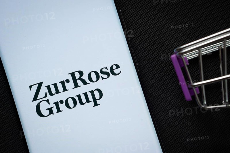 Dhaka, Bangladesh- 03 July 2025: A smartphone displaying the Zur Rose Group logo next to a miniature shopping cart on a background