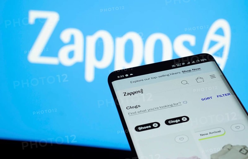 Dhaka, Bangladesh- 03 July 2025: Smartphone displaying Zappos web interface against Zappos logo background