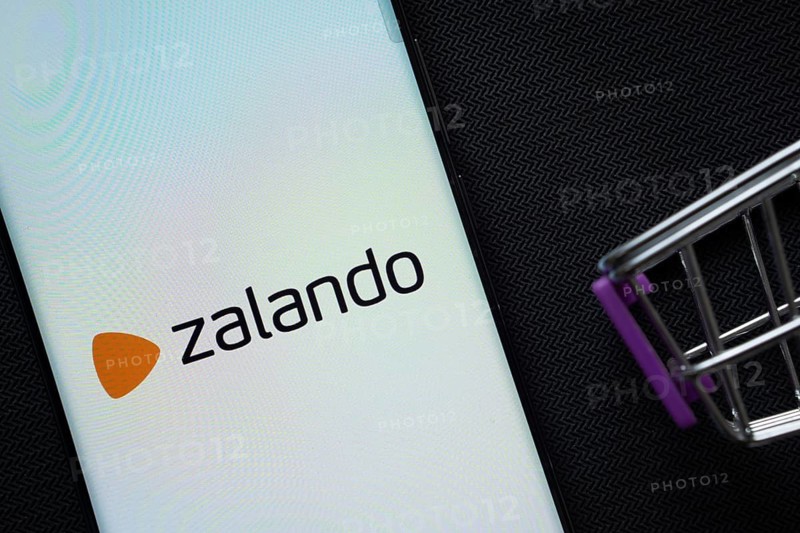 Dhaka, Bangladesh- 03 July 2025: A smartphone displaying the Zalando logo next to a miniature shopping cart on a background