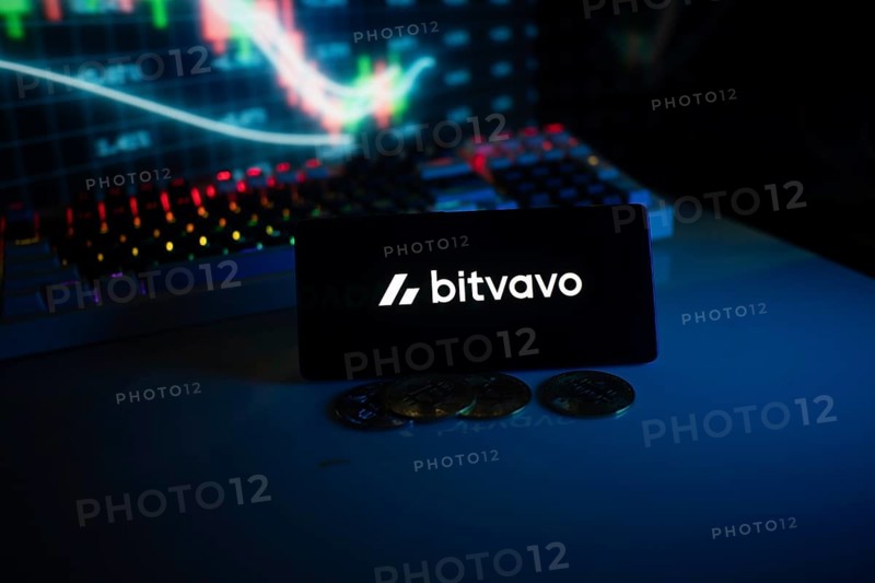 Bitvavo display with coins in front of a lit stock chart in blue neon ambiance