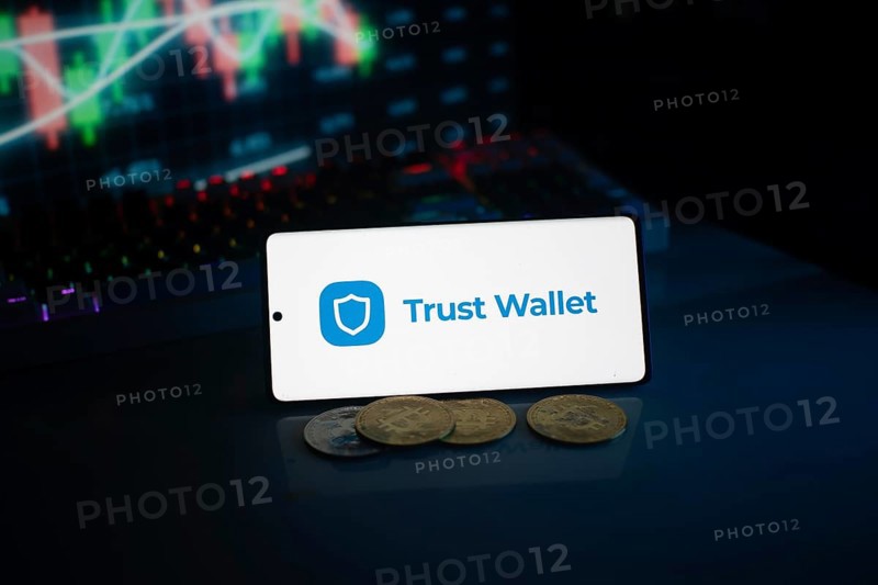 Trust Wallet display with coins against a stock chart backdrop in neon lighting
