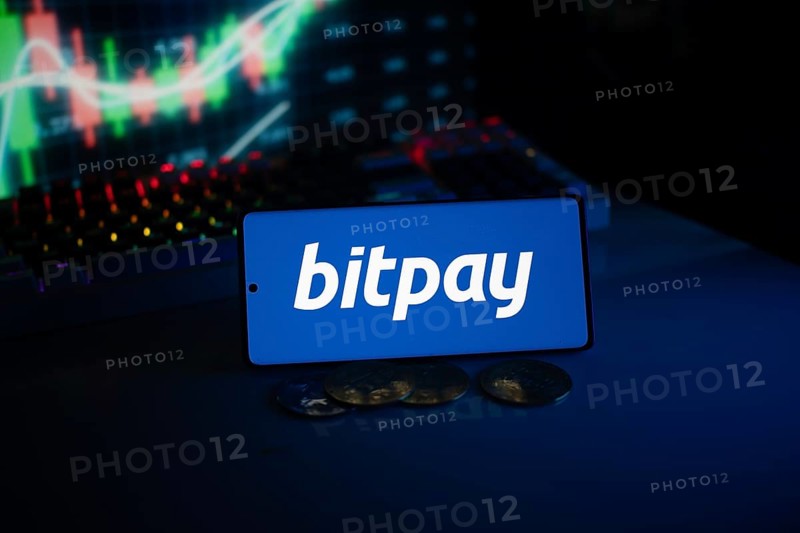 Bitpay logo presented with coins and glowing market graphs, reflecting digital commerce