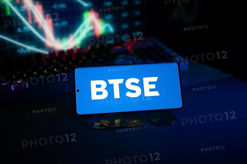 BTSE logo on smartphone with coins and stock chart, suggesting finance and digital market