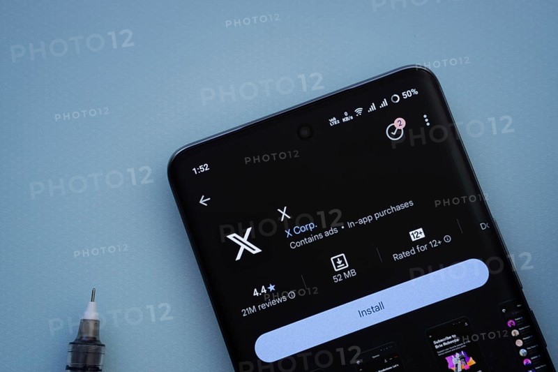 Dhaka, Bangladesh- 29 May 2025: On a blue surface, a smartphone displays the X app within the Google Play Store