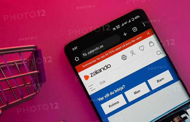 Dhaka, Bangladesh- 23 June 2025: A smartphone displaying the Zalando website with a shopping cart is shown on a vibrant background