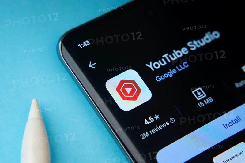 Dhaka, Bangladesh- 29 May 2025: On a blue surface, a smartphone displays the youtube studio app within the Google Play Store