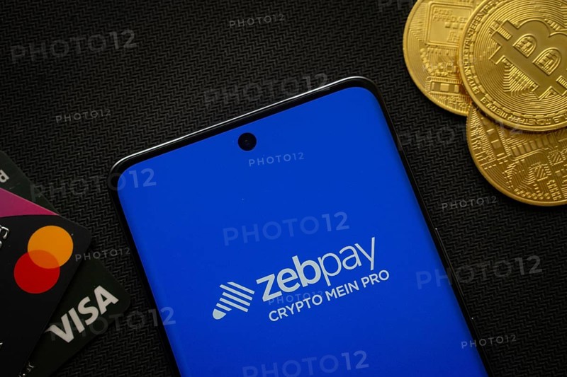 Dhaka, Bangladesh- 15 June 2025: Smartphone displaying zebpay logo surrounded by Bitcoin coins and payment cards