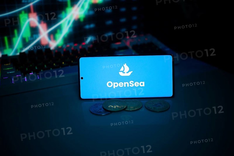 OpenSea on a smartphone with coins and market data on a screen