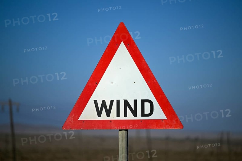 Caution wind sign on a road near Oranjemund, diamond restricted area, Karas region, Namibia