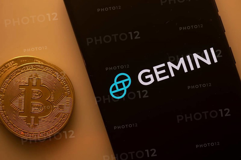 Black Gemini screen and Bitcoin coin, symbolizing cryptocurrency exchange