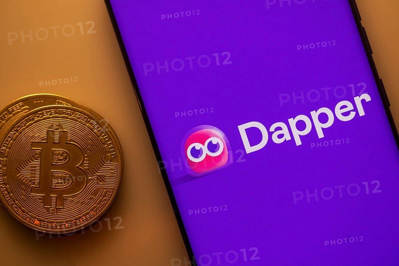 Dapper logo displayed on a smartphone next to a Bitcoin coin