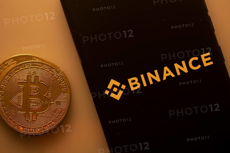 Bitcoin coin with Binance logo on a black background, linking to digital currency trading