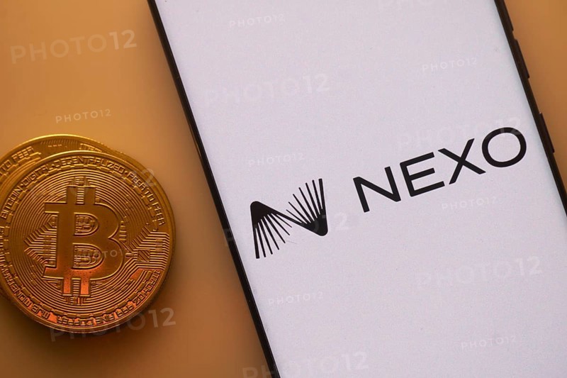 Nexo logo on smartphone screen beside Bitcoin, highlighting financial technology and cryptocurrency lending