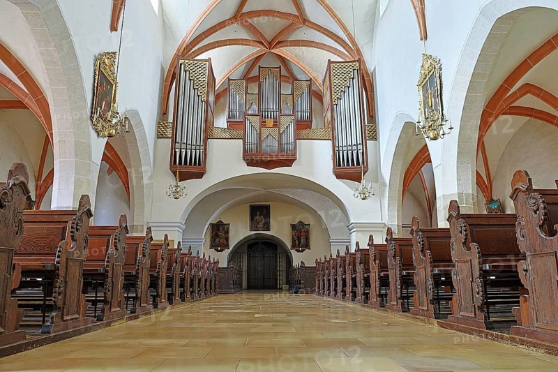 Interior of a church with detailed wooden benches and an impressive organ on the ceiling, St.Stephan parish church in Tulln Lower Austria Austria