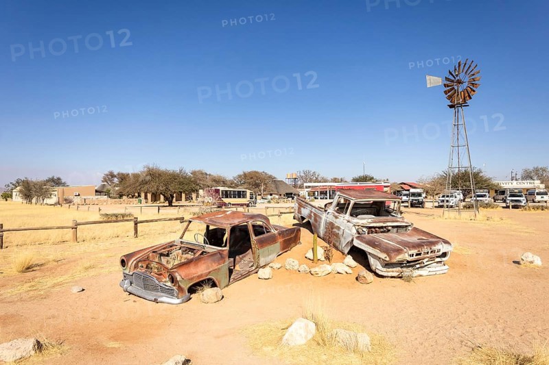 Solitaire's car graveyard in Namibia - 27 August, 2025: features rusted vintage cars near small desert buildings, set against dunes and mountains, capturing desert charm and isolation