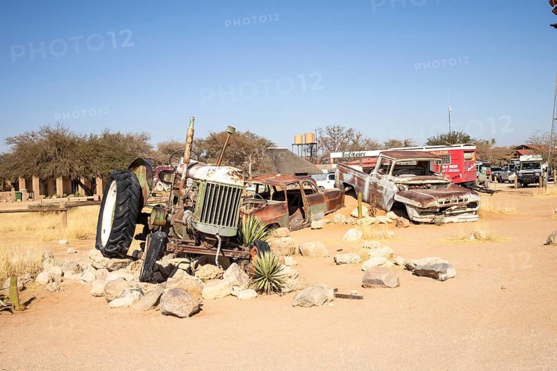 Solitaire's car graveyard in Namibia 27 August, 2025: features rusted vintage cars near small desert buildings, set against dunes and mountains, capturing desert charm and isolation