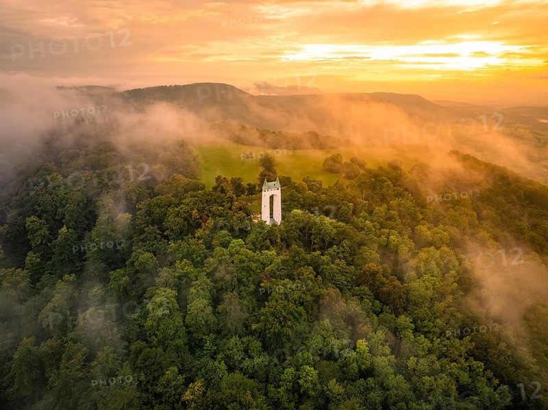 A foggy morning with a tower surrounded by green hills, Schönbergturm, Pfullingen, Swabian Alb, Germany