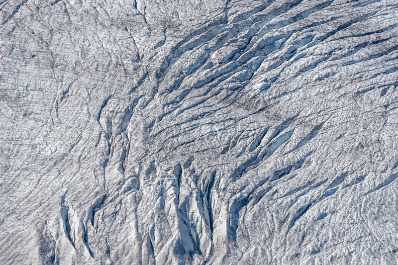 Crevices mark the surface of the glacier. The landscape is illuminated by daylight, highlighting the structure and colour of the ice. Gorner Glacier, Zermatt, Valais, Alps, Swiss