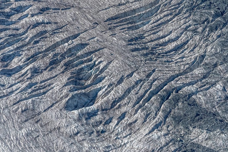 Crevices mark the surface of the glacier. The landscape is illuminated by daylight, highlighting the structure and colour of the ice. Gorner Glacier, Zermatt, Valais, Alps, Swiss