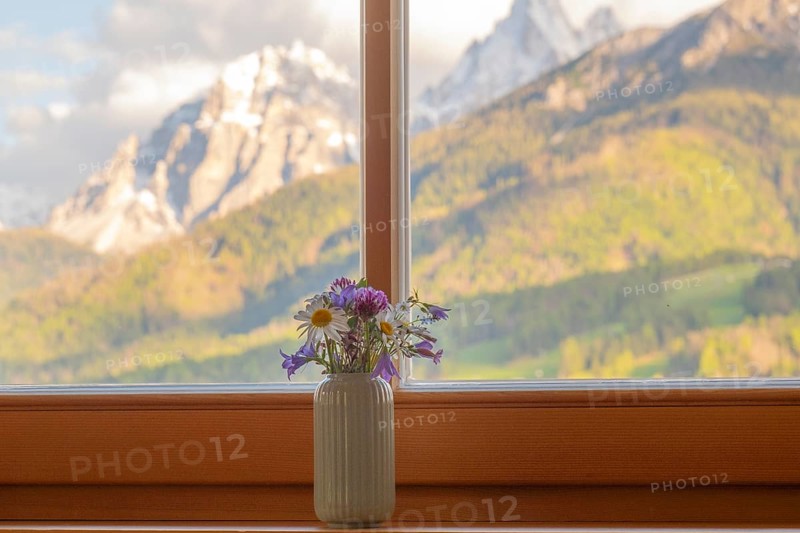 A vase with meadow flowers stands on the windowsill in the background the mountains of the Dolomites, San Candido, Val Pusteria, Sesto Dolomites, Dolomites, South Tyrol, Italy