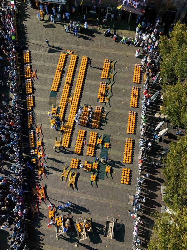 Aerial view of a busy market square with lots of cheese wheels and people at a sunny festival, aerial view, cheese, cheese market, Alkmaar, Alkmar, Noord-Holland, North Holland, Netherlands