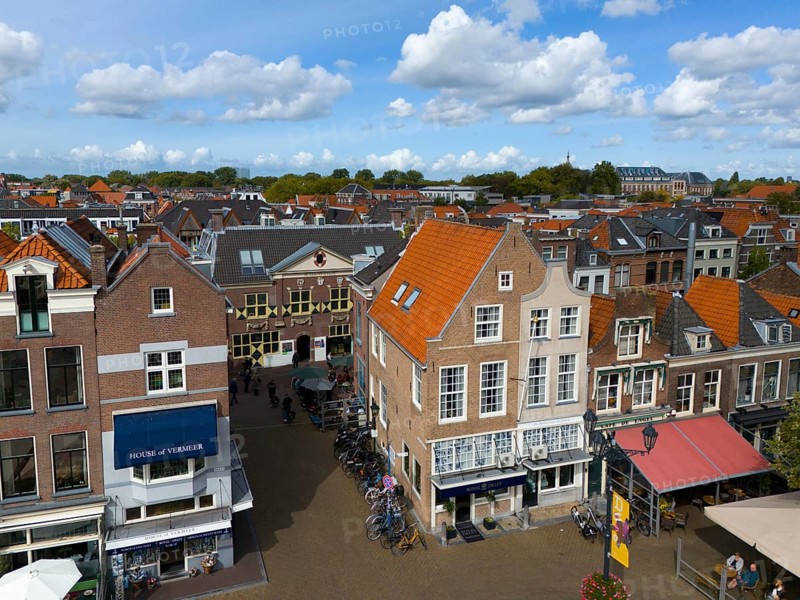 Urban street scene with shops, old buildings and bicycles under a cloudy sky, aerial view, houses at the market square, Delft, Province of South Holland, Zuid-Holland, Netherlands
