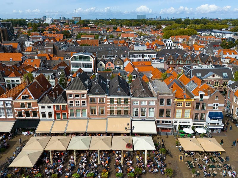 Row of town houses with red roofs and lively restaurant area in the foreground, aerial view, merchants' houses on the market square, Delft, province of South Holland, Zuid-Holland, Netherlands