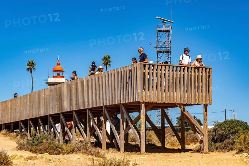 Tourists on the rocky coast of Ponta da Piedade, rugged coastal landscape, right next to Lagos city centre, in the west of the Algarve, Portugal