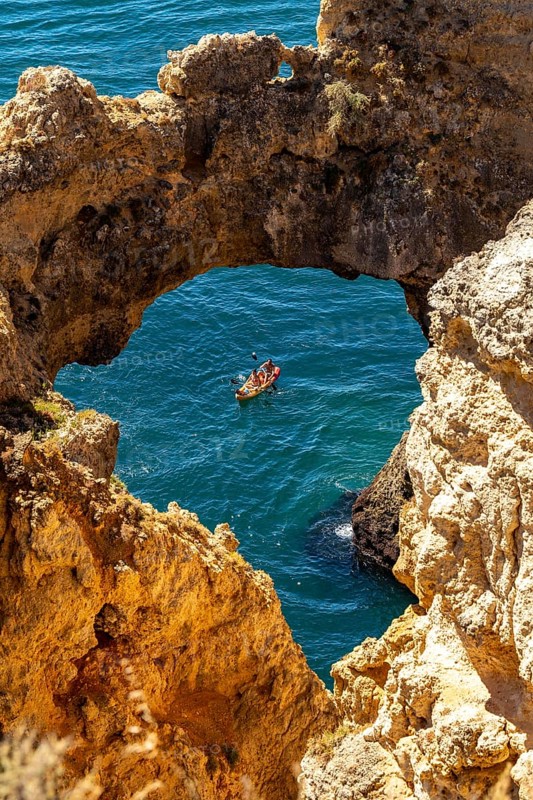 Excursion boats at the caves and rocky gates of the Ponta da Piedade rocky coast, rugged coastal landscape, right by the centre of Lagos, in the west of the Algarve, Portugal
