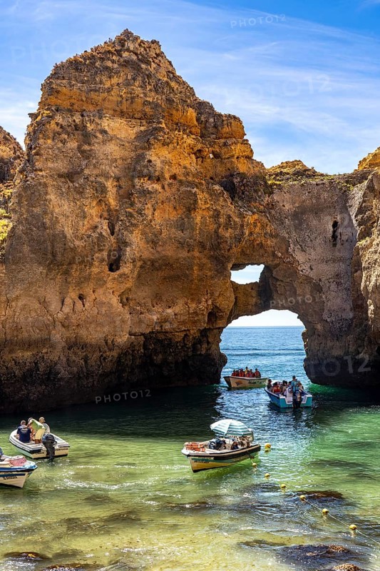 Excursion boats at the caves and rocky gates of the Ponta da Piedade rocky coast, rugged coastal landscape, right by the centre of Lagos, in the west of the Algarve, Portugal