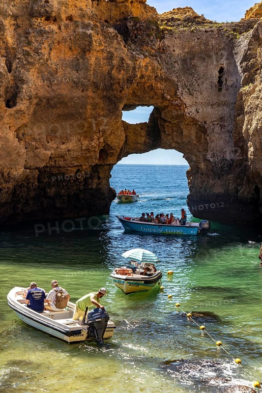 Excursion boats at the caves and rocky gates of the Ponta da Piedade rocky coast, rugged coastal landscape, right by the centre of Lagos, in the west of the Algarve, Portugal