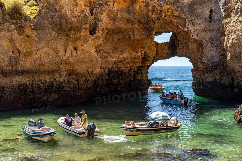 Excursion boats at the caves and rocky gates of the Ponta da Piedade rocky coast, rugged coastal landscape, right by the centre of Lagos, in the west of the Algarve, Portugal