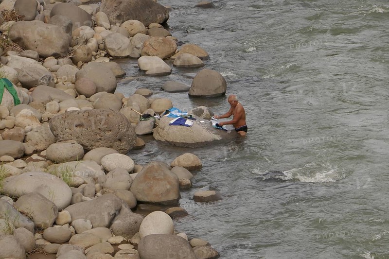 Old man washing his clothes in the river, Negros Occidental, Philippines